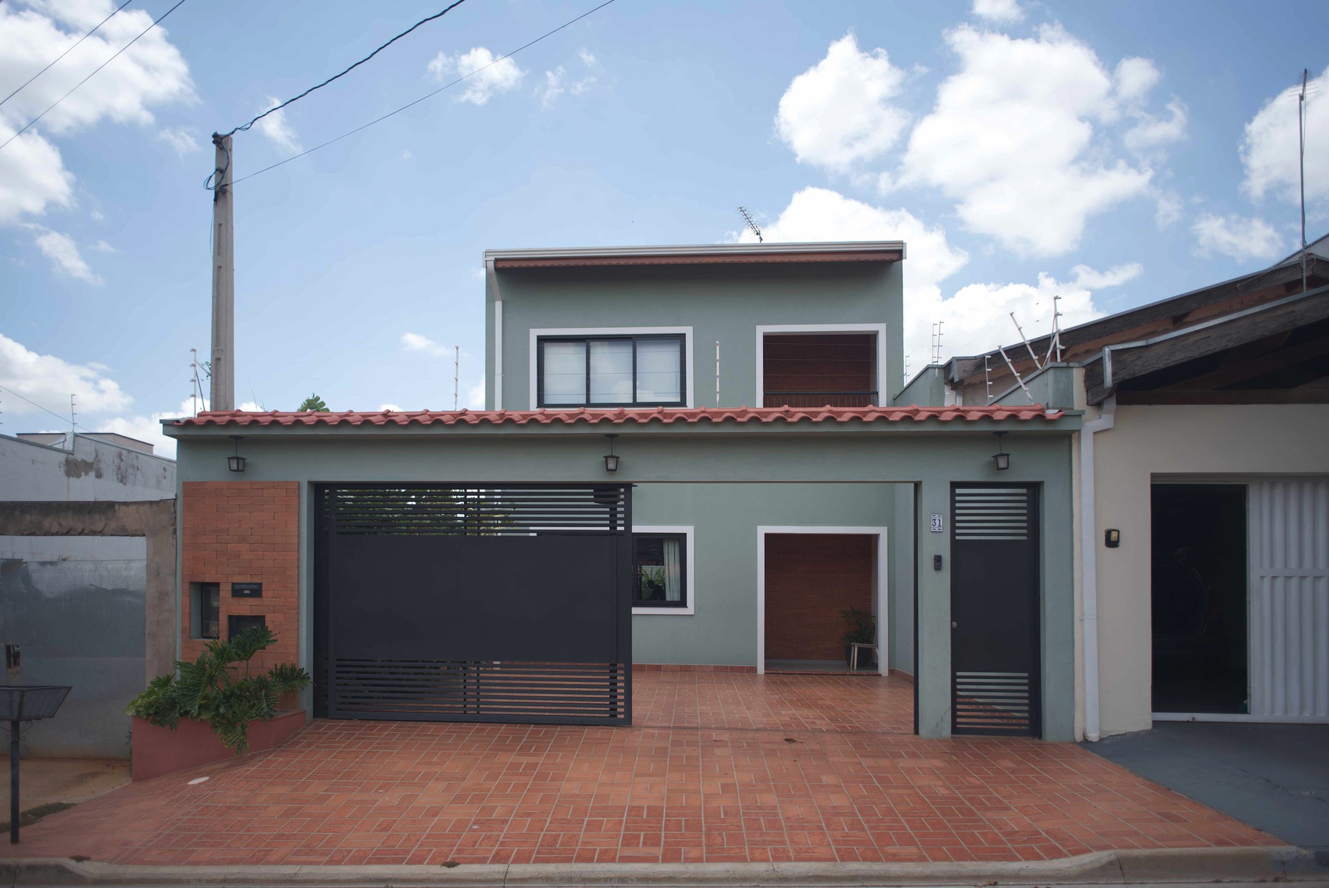 Fachada de sobrado moderno cor verde sálvia com portão permeável em Limeira SP