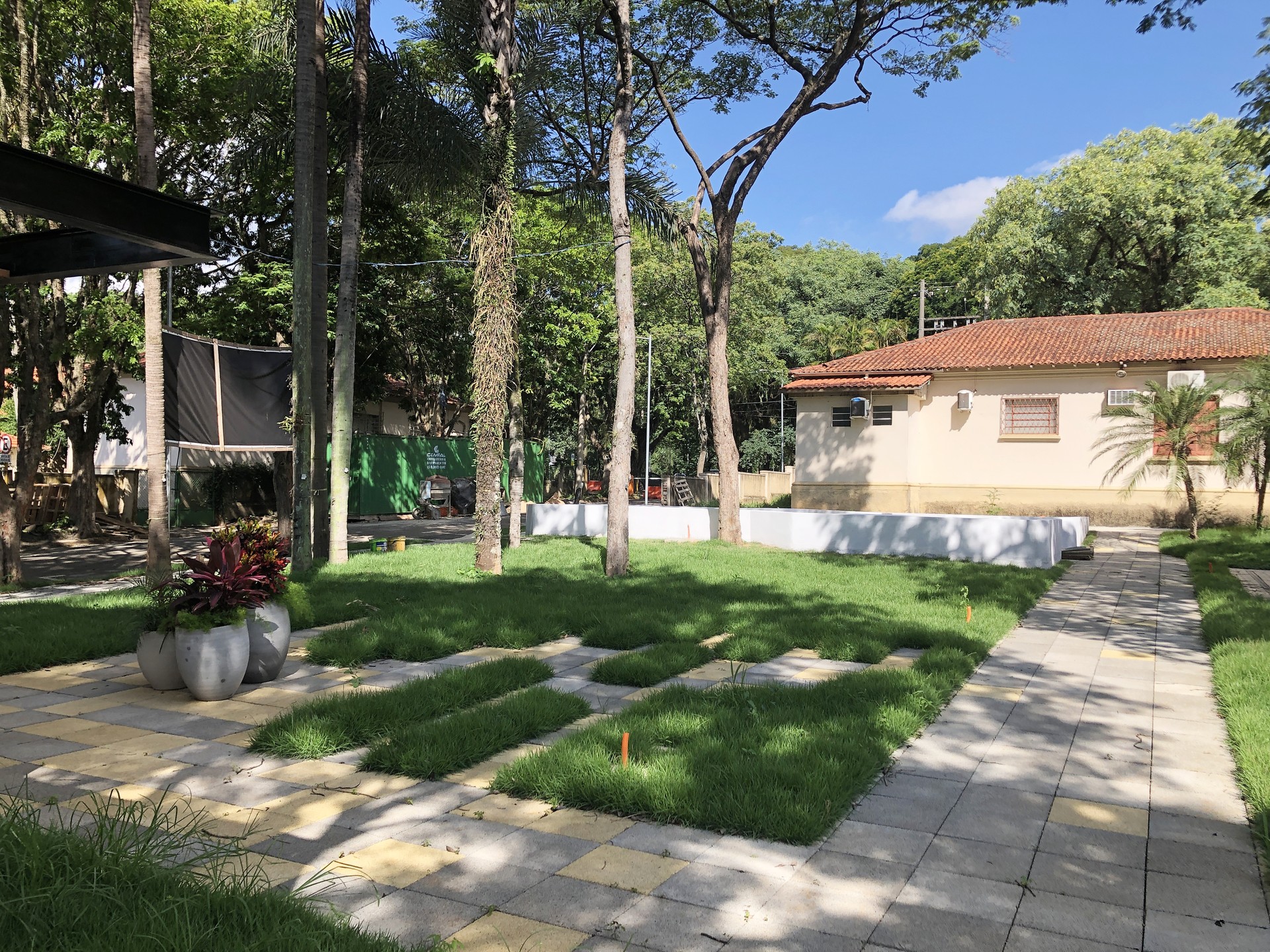 Jardim interno com gramado e áreas de permanência